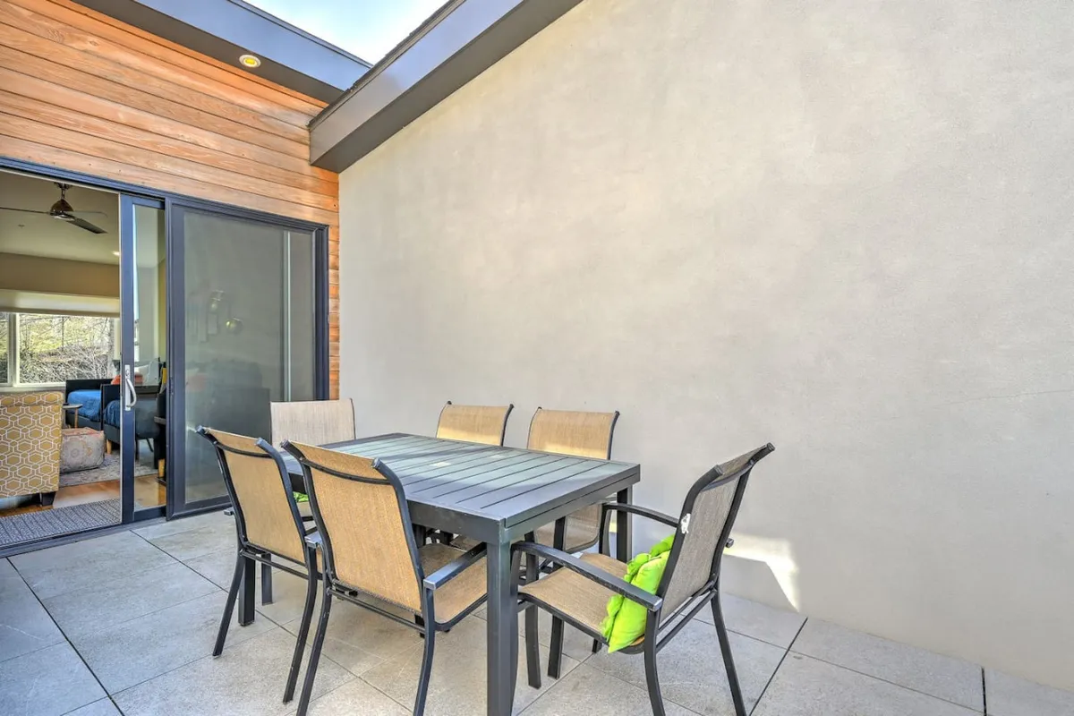 A stylish exterior dining set complete with comfortable chairs and a verdant accent pillow, emphasizing a space made for enjoying meals, afternoon coffee, or evening chats outdoors.