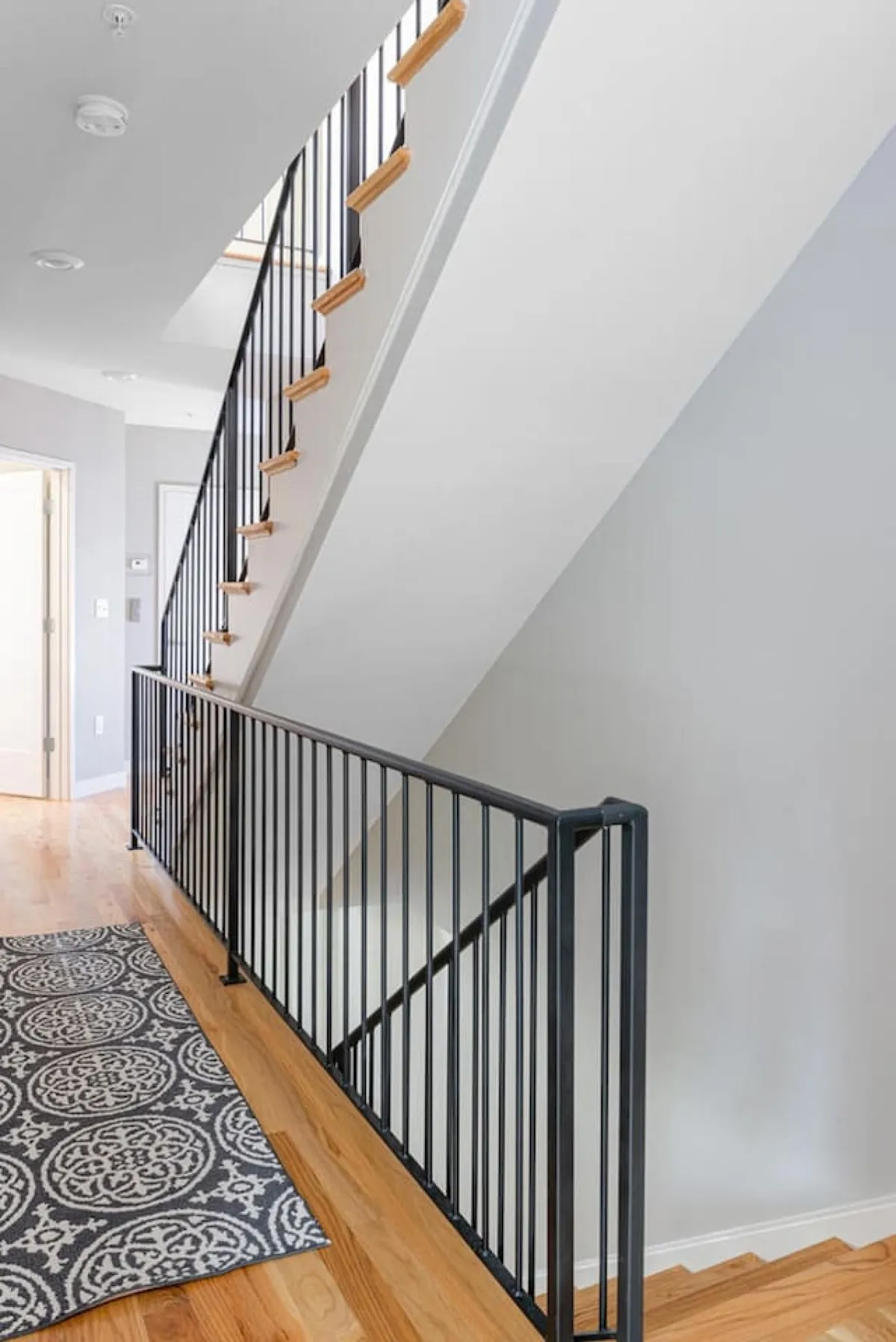 An elegant interior entry hall showcasing a staircase, tasteful rug, and contemporary wall color. The focus on the transitional area underscores the significance of entry and first impressions.